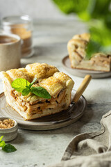 Piece of homemade apple pie with mint leaf on textured background