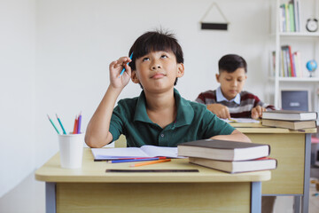 Fototapeta na wymiar Confused llementary school boy when doing exams in class