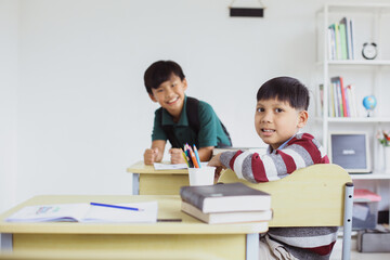 Fototapeta na wymiar Asian schoolboys posing and looking at camera in the classroom