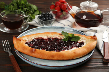 Delicious sweet cottage cheese pastry with cherry jam served on wooden table
