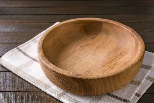 Empty plate on napkin on wooden table over grunge blue background.