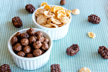 Different types of cornflakes on a breakfast table.