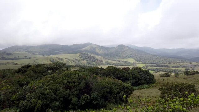  A Dramatic Panoramic view of the Bewitching Kote betta mountain range with landscapes and lush green foliage during monsoon in Coorg, Karnataka, India.