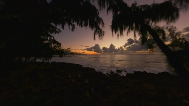 North Shore Oahu's Banzai Pipeline, Surfers at Sunset in the Pacific Ocean Shot with FPV Drone Through Trees