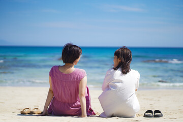 Fototapeta na wymiar 砂浜で会話する女性