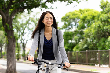 Fototapeta na wymiar 笑顔で自転車通勤する女性・スマートフォンの操作