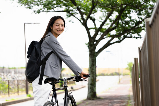笑顔で振り向く女性・自転車の通勤イメージ