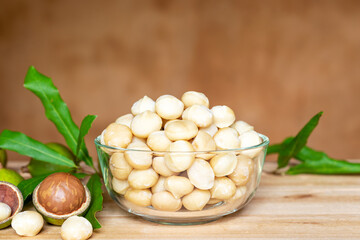 roasted macadamia nut in glass bowl on wooden table.