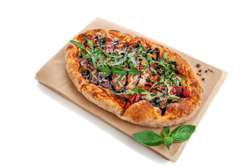 Roman pizza with roasted vegetables arugula and balsamic sauce on a wooden tray. Decorated with basil and spices. White background. Isolated.