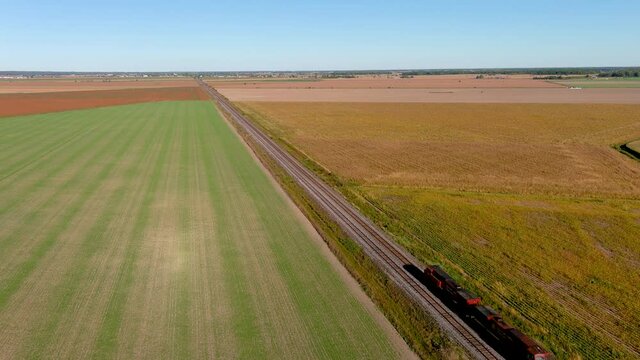 Transportation industry: freight train traveling on countryside, 4K UHD drone aerial footage.