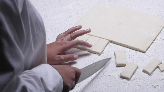 cutting little pieces of dough for making khari
