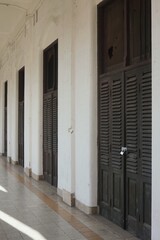 Perspective view of large wooden doors in corridor of abandoned old European style building. No people. 