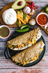 Mexican quesadilla typical food stuffed with mushrooms or chicharron, cheese and squash blossom with sauce in Mexico