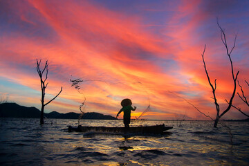Silhouettes of the traditional stilt fishermen at sunset.