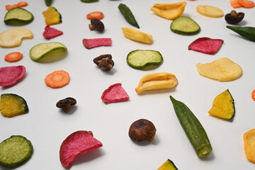 Colorful dried vegetables chips on white background.