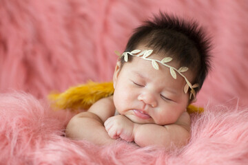 A cute newborn boy wearing a headband and small angle wing sleeping on a pink soft blanket, Infant, babyhood concept and copy space - Image