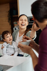 Young playful family has fun while having breakfast together at home.