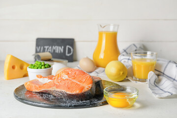 Raw salmon pieces and different healthy products on light background