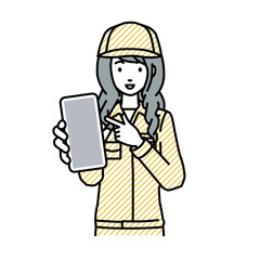 立ってスマートフォンを指差してこちらに向けて見せている作業員の女性