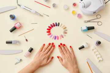 Female hands and tools for manicure on color background