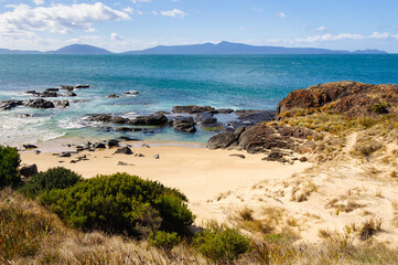 Spiky Beach is a remote sandy beach with a rocky shore surrounded by low hills - Swansea, Tasmania, Australia