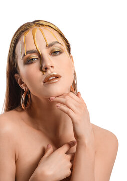 Beautiful young woman with  golden paint on her face against white background