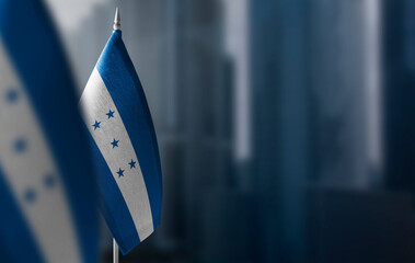 Small flags of Honduras on a blurry background of the city