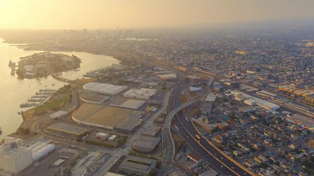 Aerial capture of the Nimitz Freeway and Coast Guard Island Alameda in the background during sunset in Oakland, California.
