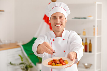 Italian chef with delicious pasta and basil in kitchen