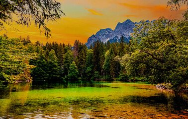 Lake Bader. Badersee Grainau and View to the Waxenstein, Zugspitze Mountain. Trees and variegated foliage. landscape scene with reflections in Idyllic and calm pond water. Bavarian alps. Bavaria.  