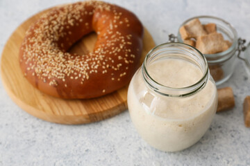 Open jar with fresh sourdough on white background
