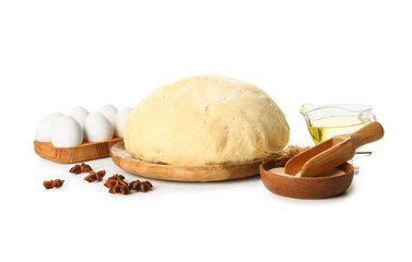 Wooden board with fresh dough, dry yeast and ingredients on white background
