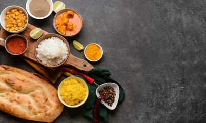 Traditional Indian food with spices on dark background