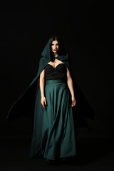 Beautiful woman dressed as witch for Halloween party on dark background