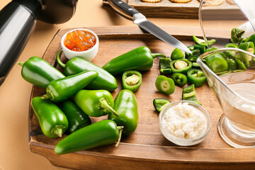 Board with jalapeno peppers and bowl with cottage cheese on color wooden table, closeup