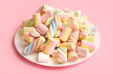 Plate with tasty marshmallows on color background