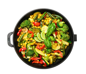 Frying pan with different vegetables on white background