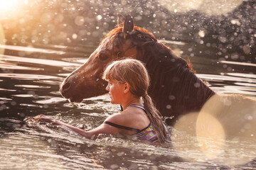Mädchen badet mit Pferd im See
