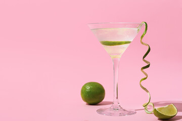 Glass of gin and tonic on color background