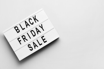 Board with text BLACK FRIDAY SALE on light background