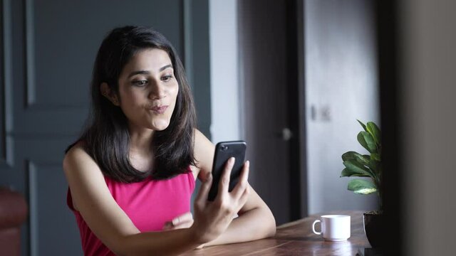 Young indian Woman making a video call smiling and talking with her friend and family. Businesswoman having video call discussing, working online meeting with team at home office.