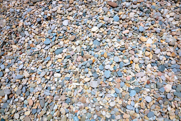 Abstract background of mutlicolored pebbles on the shore from above