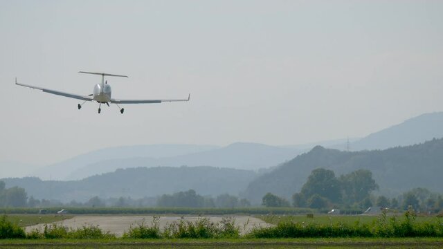 Rear view of light airplane landing and starting again with swiss alps in background