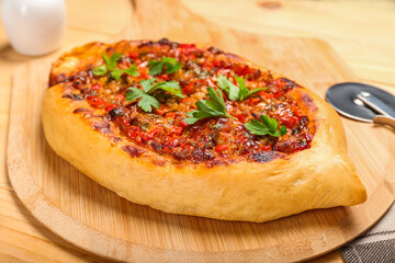 Board with Turkish Pizza on wooden background