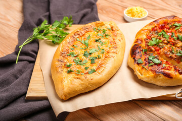 Board with tasty Turkish Pizza on wooden background