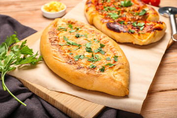 Board with tasty Turkish Pizza on wooden background