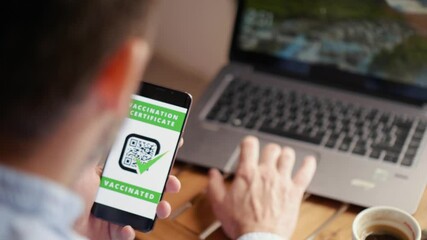 Man drinking coffee in a restaurant  showing digital vaccine passport. COVID  Pass for entry to restaurants, cinemas, shopping malls, hospitals - Powered by Adobe