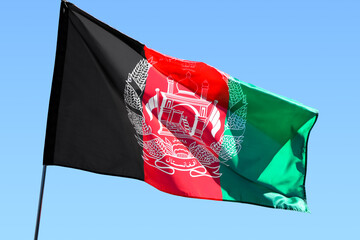 Waving Afghanistan flag against blue sky