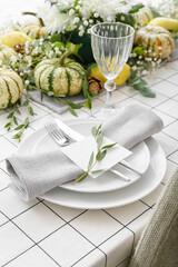 Stylish table setting with card and autumn decor in restaurant