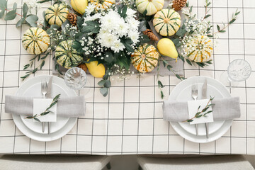 Festive table setting with card and autumn decor in restaurant